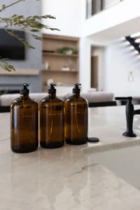 amber glass soap dispenser bottles with minimalist labels on a white counter