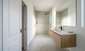 Modern small bathroom layout with a white pocket door and floating wooden vanity