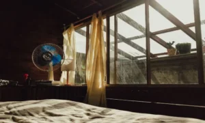 bedroom with an off-center window above a neatly made bed
