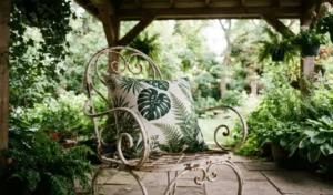 botanical-pattern outdoor cushion on a vintage patio chair beneath a covered patio, surrounded by greenery