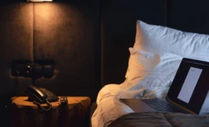 closed laptop and desk lamp turned off at the end of the day in a bedroom