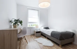 small bedroom with neatly arranged bed and minimal furniture