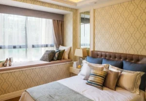 wide upholstered headboard positioned beside an off-center window]
